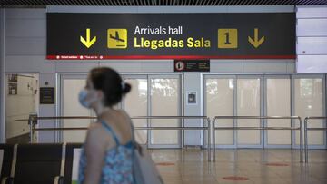 Una persona con mascarilla pasa junto a la entrada de la sala de llegadas 1 de la Terminal 1 del Aeropuerto de Barajas, en Madrid (España) a 4 de julio de 2020.
