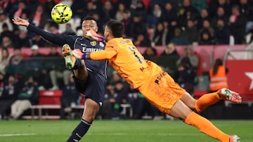 TOPSHOT - Real Madrid's French forward #10 Kylian Mbappe and Girona's Argentine goalkeeper #13 Paulo Gazzaniga (R) fight for the ball during the Spanish league football match between Girona FC and Real Madrid CF at Montilivi Stadium in Girona on November 30, 2025. (Photo by Josep LAGO / AFP)