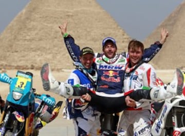 El piloto español Marc Coma celebra su triunfo final en la categoría de motos del Rally de los Faraones 2011, Egipto, junto al portugués Helder Rodrigues, segundo, y el polaco Jakub Przygonski, tercero,.