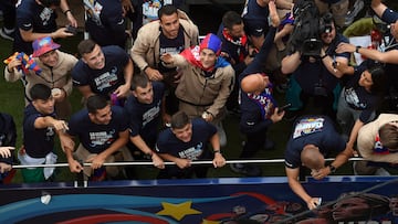 Barcelona's Spanish midfielder Gavi (C) waves as the players and staff of FC Barcelona men football team parade aboard a open-top bus followed by the women's team (out of frame), to celebrate their La Liga titles in Barcelona on May 15, 2023. The FC Barcelona women's team won its fourth consecutive La Liga title on April 30 after scoring 3-0 against Sporting de Huelva at the Estadi Johan Cruyff while the men's team yesterday won their 27th La Liga tile by thrashing Espanyol 4-2, wrestling the title back from rivals Real Madrid. (Photo by Josep LAGO / AFP)