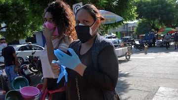 People wear face masks in the surroundings of Pascuales cemetery, north of Guayaquil, Ecuador on May 18, 2020. - The Pascuales cemetery was filled with deads and life was extinguished around it during the spread of the Covid-19 coronavirus pandemic. Locat