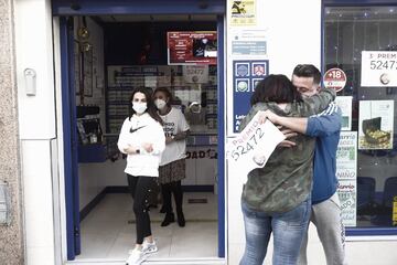 Varias personas celebran el tercer premio, el número 52472, en la localidad gaditana de Barbate. Esta administración, la número 2, ha repartido 45 millones de euros.