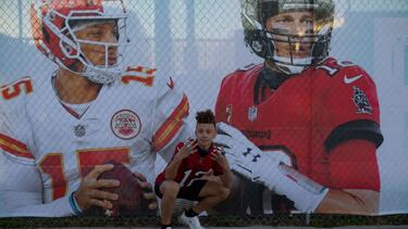 Tampa (United States), 03/02/2021.- A passer-by poses in front of a fence banner with the portraits of Super Bowl LV quarterback Patrick Mahomes (L) and Tom Brady, ahead of the NFL Super Bowl LV in Tampa, Florida, USA, 04 February 2021. The AFC Champion K
