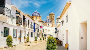 Street of Altea old town in Spain. Beautiful village with white houses and blue domed church Our Lady of Solace. Popular Spanish tourist destination in Costa Blanca region