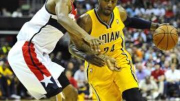 Paul George (24) intenta sortear a Trevor Ariza (1).