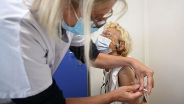A woman receives a dose of the Pfizer-BioNTech vaccine against Covid-19 in the mobility bus "vacci bus" touring Ajaccio, on the French Mediterranean island of Corsica, on April 28, 2021. (Photo by Pascal POCHARD-CASABIANCA / AFP)
