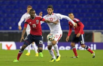 El colombiano Brian Ramos (i) y el tunecino Sassi Ferjani (d) durante el partido amistoso disputado hoy en el estadio de Cornellà-El Prat.