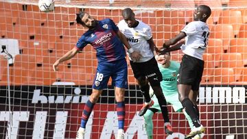 Huesca's Greek defender Dimitrios Siovas (L) vies with Valencia's French midfielder Geoffrey Kondogbia (C) and Valencia's French defender Mouctar Diakhaby during the Spanish league football match Valencia CF against SD Huesca at the Mestall