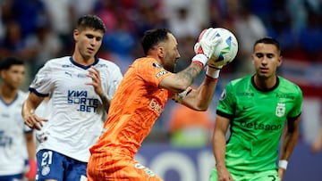 Atletico Nacional's goalkeeper #01 David Ospina grabs the ball next to Bahia's Argentine defender #21 Santiago Ramosduring the Copa Libertadores group stage football match between Brazil's Bahia and Colombia's Atletico Nacional at the Arena Fonte Nova stadium in Salvador, state of Bahia, Brazil, on April 24, 2025. (Photo by Arisson MARINHO / AFP)