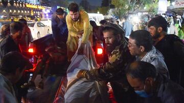 EDITORS NOTE: Graphic content / Volunteers and medical staff unload bodies from a pickup truck outside a hospital after two powerful explosions, which killed at least six people, outside the airport in Kabul on August 26, 2021. (Photo by Wakil KOHSAR / AF