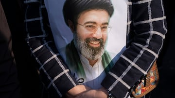 A young Iranian woman hugs a portrait of Iran's new Supreme Leader, Ayatollah Mojtaba Khamenei, the son of the late Leader Ayatollah Ali Khamenei, during a rally to pledge allegiance to Mojtaba Khamenei amid the U.S.-Israeli military campaign in Tehran, Iran, on March 9, 2026. (Photo by Morteza Nikoubazl/NurPhoto via Getty Images)