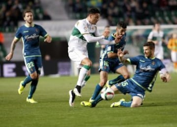 El delantero del Elche Cristian Herrera (c) intenta superar al defensa del Real Valladolid Chus Herrero (d) durante el partido de vuelta de dieciseisavos de final de la Copa del Rey, disputado esta tarde en el estadio Martínez Valero.