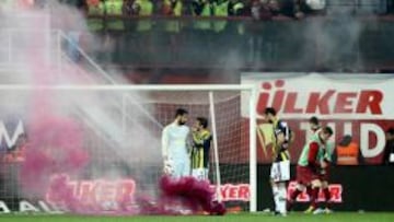 Los jugadores del Fenerbahçe discuten entre bengalas lanzadas desde la grada, en el partido ante el Trabzonspor.