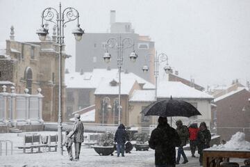 Varias personas pasean por la calle mientras nieva en León, Castilla y León (España). La Agencia Estatal de Meteorología (Aemet) ha activado la alerta naranja en las zonas de la Cordillera Cantábrica y el Bierzo. 