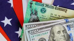 Cheque del Departamento del Tesoro sobre la bandera estadounidense y billetes de 100 d&oacute;lares.