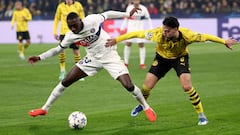 Paris Saint-Germain's French forward #23 Randal Kolo Muani (L) and Dortmund's Algerian defender #05 Ramy Bensebaini vie for the ball during the UEFA Champions League group F football match between BVB Borussia Dortmund and Paris Saint-Germain in Dortmund, western Germany, on December 13, 2023. (Photo by FRANCK FIFE / AFP)