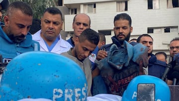 Colleagues of Palestinian journalists Mohammed Soboh and Saeed al-Taweel, who were killed when an Israeli missile hit a building while they were outside reporting, stand next to their bodies at a hospital in Gaza City.