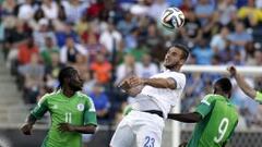 El futbolista griego Panagiotis Tachtsidis (c) disputa el bal&oacute;n con los nigerianos Victor Moses (i) y Emmanuel Emenike (d).