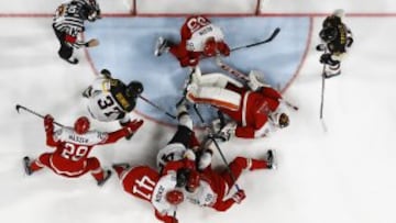 Jugadores de Dinamarca y Alemania peleando por el disco en el mundial de hockey hielo 2023.