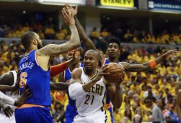 Tyson Chandler (L) e Iman Shumpert (R) de los New York Knicks acorralan a David West de los Indiana Pacers durante el partido de los Playoffs de la NBA de la conferencia Este