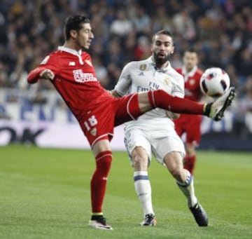  El defensa del Real Madrid, Dani Carvajal lucha por el balón con el defensa Sergio Escudero del Sevilla durante el partido de ida de los octavos de la Copa del Rey disputado en el estadio Santiago Bernabéu en Madrid. 