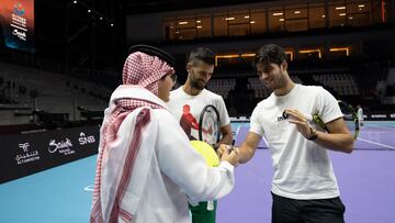 Novak Djokovic y Carlos Alcaraz firman pelotas gigantes.