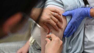 This picture taken on February 15, 2022 shows a 13-year-old junior high school student (R) receiving the HPV vaccine at a hospital in Tokyo. - The percentage of teenage girls getting the HPV vaccine has been close to zero since the country's 2013 decision not to promote the jab as panic erupted over alleged side effects, but from April 1, 2022 authorities will actively recommend and share information about the vaccine, which is free for girls aged 12-16 in Japan and has been found safe in extensive trials. (Photo by Kazuhiro NOGI / AFP) / TO GO WITH Japan-vaccines-health-cancer-HPV-women,FOCUS by Natsuko FUKUE