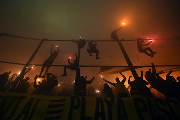 Hnchas de Peñarol animan a su equipo subidos a una valla con bengalas en el partido de vuelta de los cuartos de final de la Copa Libertadores, entre el conjunto uruguayo y el Flamengo brasileño. El choque comenzó con retraso por el humo de las bengalas y de los fuegos artificiales lanzados en el estadio Campeón del Siglo de Montevideo.