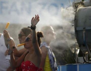 Varios aficionados se refresca delante de un ventilador en el Abierto de 2014 de Australia en Melbourne