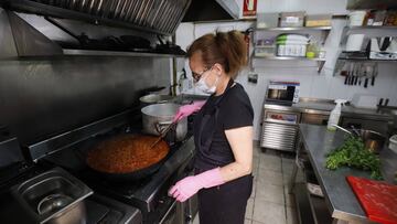 Una cocinera prepara la comida en su restaurante.