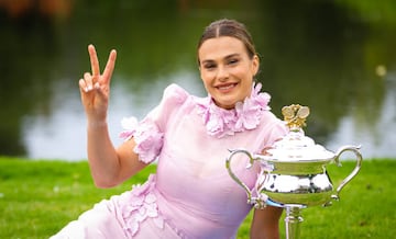 Aryna Sabalenka posando, haciendo el gesto de victoria con los dedos ¨ªndice y coraz¨®n, con el trofeo de campeona del Abierto de Australia en los Jardines Reales de Melbourne.