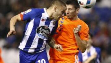 El delantero uruguayo del Deportivo Jonathan Rodr&iacute;guez disputa un bal&oacute;n con el defensa del Llagostera Aimar.