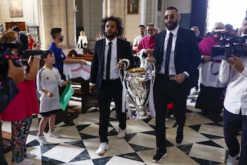 Los capitanes del Real Madrid, el brasileño Marcelo (i) y el francés Karim Benzema (d), con el trofeo a su llegada a la Catedral de la Almudena.