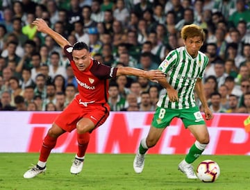 El centrocampista japonés del Real Betis, Takashi Inui, intenta escaparse del centrocampista del Sevilla FC, Roque Mesa