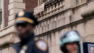 FILE PHOTO: Police stand guard in the foreground as protesters show support for Palestinians in Gaza, at Columbia University in New York City, U.S., April 24, 2024. REUTERS/David 'Dee' Delgado/File Photo