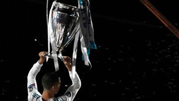Real Madrid's Portuguese forward Cristiano Ronaldo holds the trophy at the Santiago Bernabeu stadium in Madrid on May 27, 2018 during a victory ceremony after Real Madrid won its third Champions League title in a row in Kiev. / AFP PHOTO / GABRIEL BO
