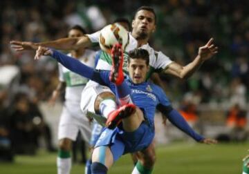 El defensa del Getafe, Sergio Escudero, despeja un balón ante el acoso del delantero brasileño del Elche, Jonathas, durante el encuentro correspondiente a la jornada 30 de primera división, que disputan esta noche en el estadio Martinez Valero de la localidad alicantina.