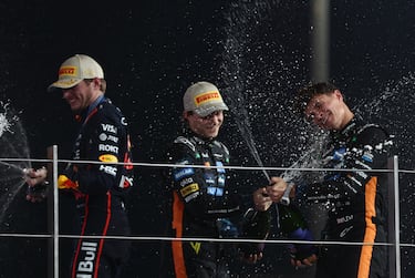 Lando Norris celebra en el podio lanzándose chámpan junto a su compañero de McLaren Oscar Piastri y el tetracampeón del mundo, Max Verstappen.