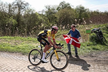 Un espectador con la bandera de Suiza anima al ciclista francés del equipo Jumbo-Visma, Christophe Laporte.