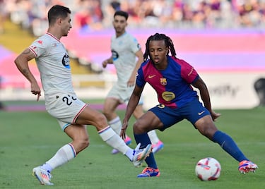 El defensa francés del Barcelona Jules Kounde lucha por el balón con el defensa brasileño del Real Valladolid Lucas Rosa durante el partido de fútbol de la liga española.