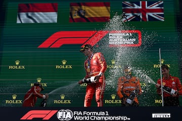Los pilotos de Ferrari, Carlos Sainz y Charles Leclerc, se rocían con champán en el podio del GP de Australia.