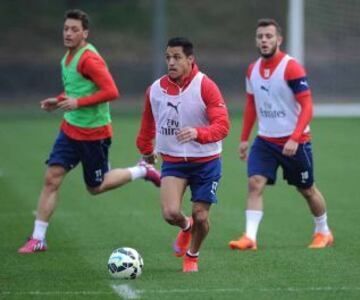 Alexis Sánchez conduce el balón ante la mirada de Jack Wilshere y Mesut Özil.