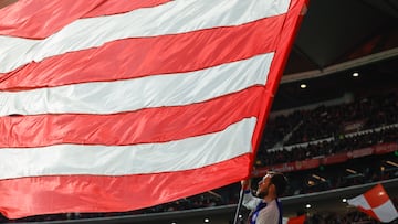 Un aficionado del Atlético porta una bandera gigante del equipo rojiblanco en un partido en el Metropolitano.