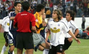 Un 10 de abril de 2005, Colo Colo jugaba de local ante la U por el Apertura de ese a&ntilde;o. Los azules ganaban 1-0 con gol de Nelson Pinto (25&#039;), pero los albos empataron con taco de Angel Carre&ntilde;o a los 82&#039;. Ah&iacute; se form&oacute; la gresca entre los jugadores, cuando Jorge Valdivia le grit&oacute; el gol en la cara al portero de la U, Johnny Herrera.