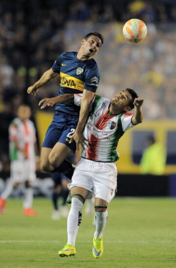 Jonathan Calleri (i) de Boca Juniors disputa la pelota con Paulo Diaz de Palestino.