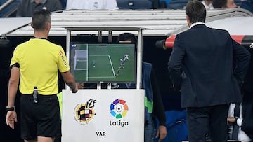Spanish referee Santiago Jaime Latre (L) and Real Madrid's Spanish coach Julen Lopetegui check the VAR screen during the Spanish league football match between Real Madrid CF and Club Deportivo Leganes SAD at the Santiago Bernabeu stadium in Madrid on Sept