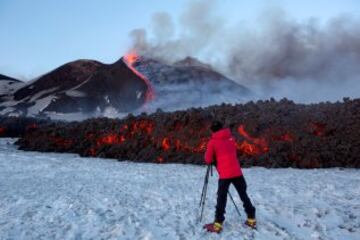 Un turista a escasos metros de la lava, con el Etna al fondo