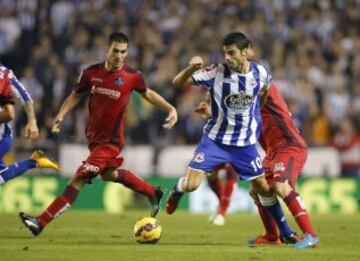 El centrocampista del Deportivo Juan Domínguez trata de librarse de varios jugadores del Getafe.