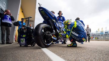 Italian Yamaha rider Valentino Rossi (Bottom R) checks his bike prior to the first training session of the Moto Grand Prix of Germany at the Sachsenring Circuit on June 30, 2017 in Hohenstein-Ernstthal, eastern Germany.  / AFP PHOTO / Robert MICHAEL