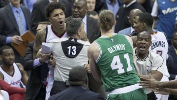 Kelly Oubre Jr. sujetado por el árbitro Monty McCutchen tras empujar a Kelly Olynyk.
